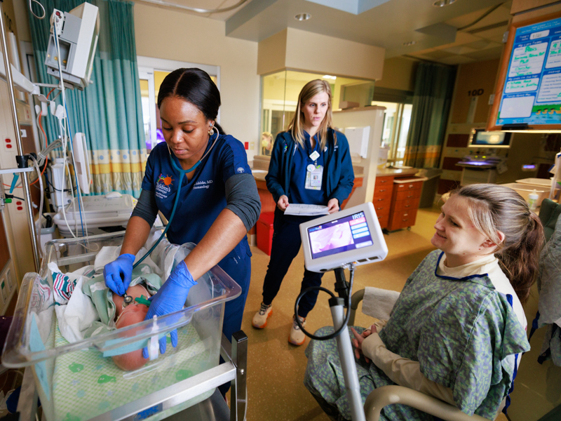 Valerie Pettit of Saltillo listens to nurse practitioner Kari Anna Adams as Dr. Omoloro Adeleke checks the heartbeat of baby Everett Helms in the NICU at North Mississippi Medical Center Women's Hospital.