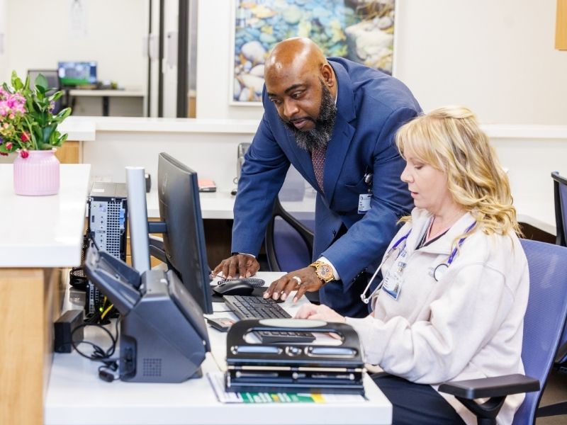 Cory Steed, field support manager for clinical health care, takes a look at one of the desktop computers at Colony Park South with Jennifer Burnell, ambulatory nurse.