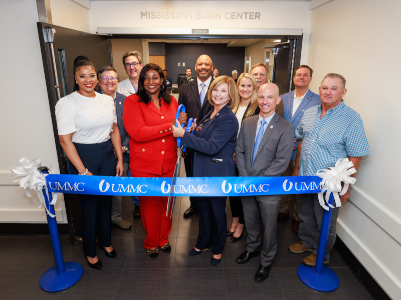 Cutting the ribbon on Monday for the opening of the new burn unit are, front row from left, Kayla Hubbard of Magee; Dr. Juvonda Hodge, director of the Mississippi Burn Center; Dr. LouAnn Woodward, vice chancellor for health affairs; Dr. Alan Jones, associate vice chancellor for health affairs; Kenneth Clark of Waynesboro. Behind are, Dr. Daniel Edney, state health officer; Dr. Peter Arnold, chief of the Division of Plastic Surgery; Dr. Al Rankins, IHL commissioner; Sherry Riser, nursing director; Gee Ogletree, IHL president; and Senator Walter Michel.