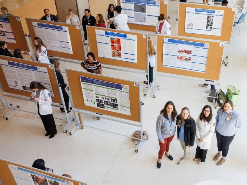 Genetic counselors Emily Boothe, second from left, and Laura Hendon, right, are joined by School of Medicine Assistant Professor Dr. Laura Coats, left, and Assistant Professor Dr.Maryam Syed at a Rare Disease Day poster symposium at the School of Medicine.