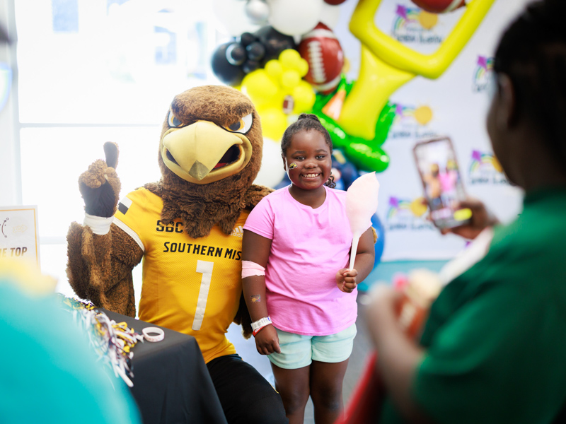 Children's of Mississippi patient Zy'ion Meardry of Waynesboro smiles for a photo with Seymour.