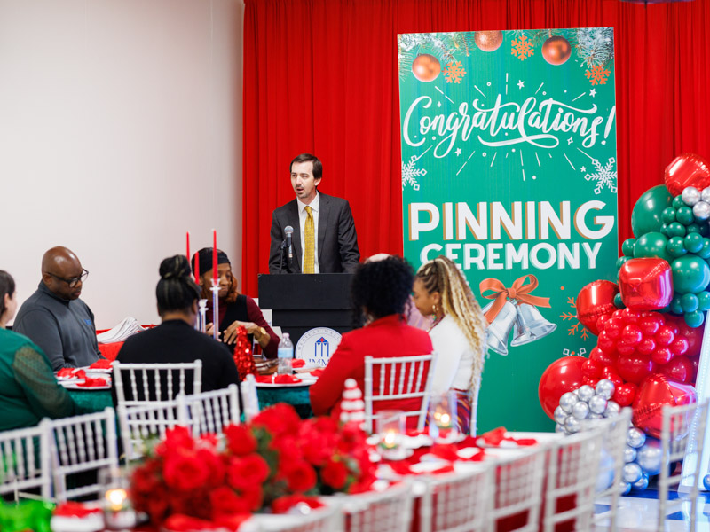 Dr. Johnathan Hontzas, director of the ACT Center, congratulates graduates during the pinning ceremony.