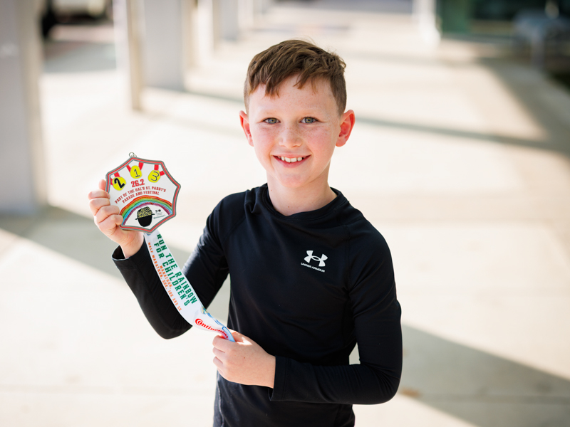 Owen Overby, 9, of Flowood, holds the 2026 Run the Rainbow medal featuring his artwork.