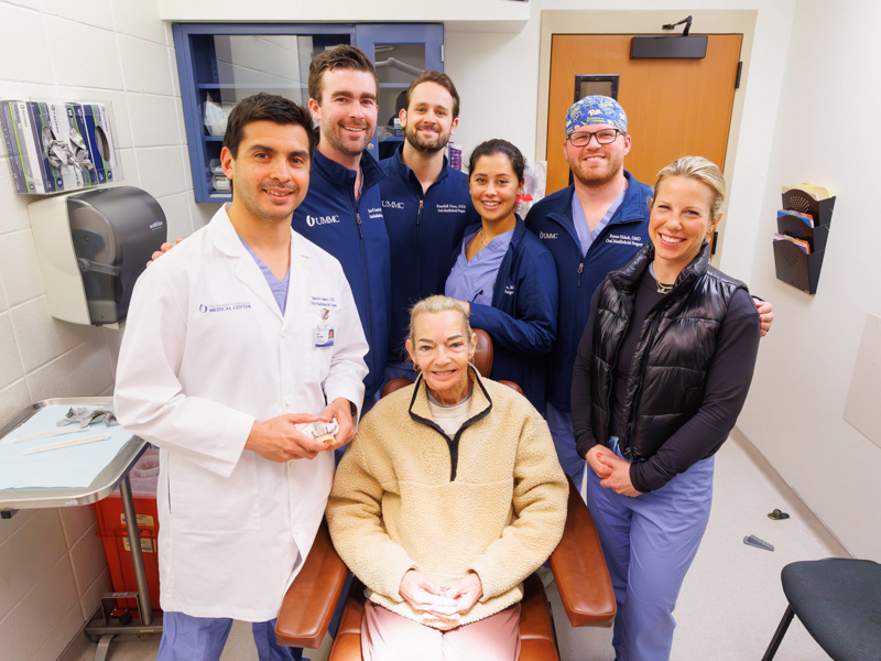 Dawn Hoge is pictured with her care team, from left, Dr. Ignacio Velasco Martinez, chair of the Department of Oral-Maxillofacial Surgery and Pathology; Dr. Jesse Austin III, Dr. Randall Nutt, Dr. Sara Islam, Dr. Bryant Halsch, OMS residents; and Dr. Laura Humphries, associate professor of plastic surgery.