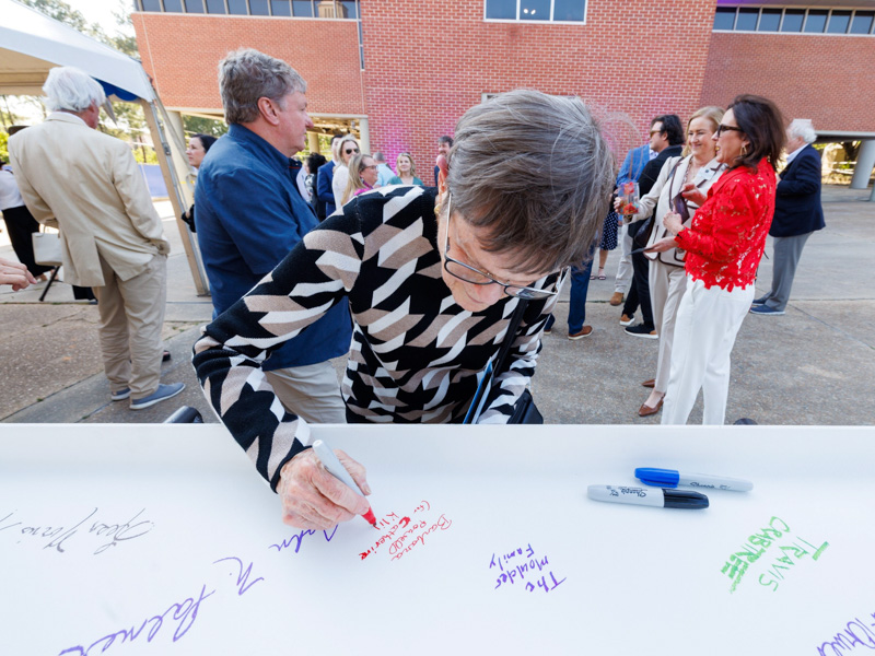 Barbara Powell, a close friend of Catherine Klipple and executor of her estate, signs a steel beam that will be used in the construction of the centralized MIND Center building.