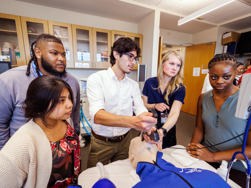 Learning incubating techniques, Victor Diaz-Ornelas, a first-year student in the P.R.O.M.I.S.E. Program, receives hands-on training from Dr. Jessie Harvey, associate professor in the School of Medicine’s Pulmonary Division, alongside three other program participants during an early clinical learning experience.