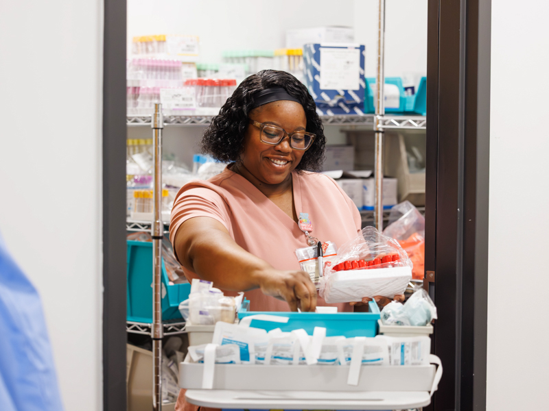 Children's of Mississippi Draw Station Clinical Lab phlebotomist LaTasha Lewis restocks a cart of blood vials and other items.