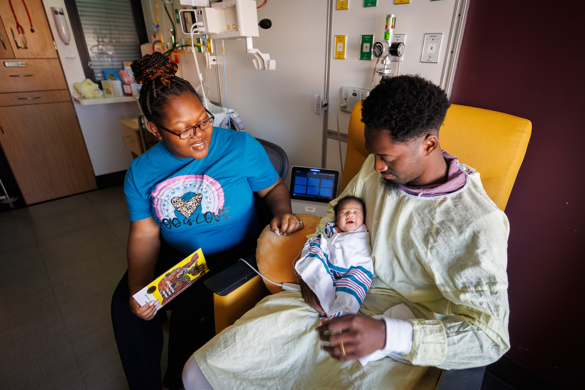 Charis Jennings of Union smiles while her parents, Tyshunda and Jaylan Jennings, read to her.