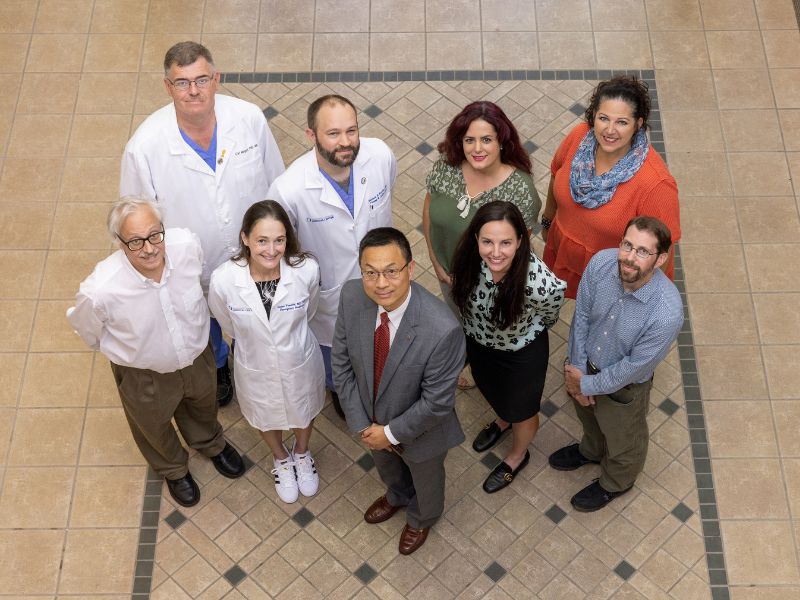 Dr. Lei Zhang, center is joined by co-investigators on the Violence Injury Prevention program, left, and Intimate Partner Violence Initiative, right. Pictured are, front row, from left, Dr. Bill Hillegass, Dr. Laura Vearrier, Zhang, Dr. Erin Dehon and Dr. Andrew Voluse. Back row, from left, are Dr. Carl Mangum, Dr. Matthew Kutcher, Dr. Masoumeh Karimi and Tara Price.