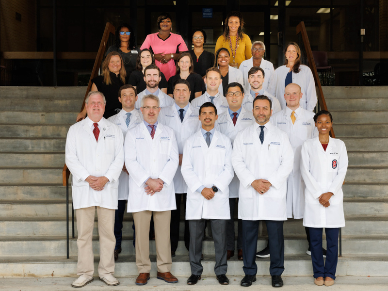 Group picture of Oral-Maxillofacial Surgery and Pathology staff standing on flight of stairs.