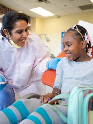 Dentist and child smiling during exam.