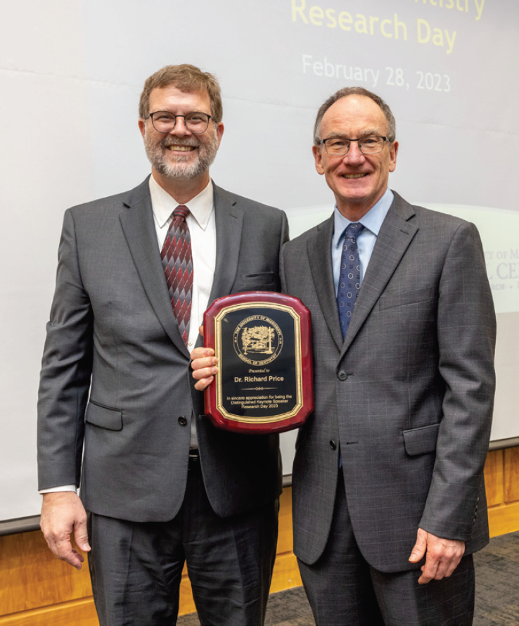 Dr. Richard Price poses with plaque. Dr. Jason Griggs is to his left.