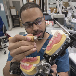 A dental student examines a mouth molds