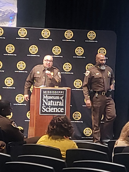 Sheriff Tyree Jones looks on as a Hinds County Sheriff's Department officer addresses the crowd.