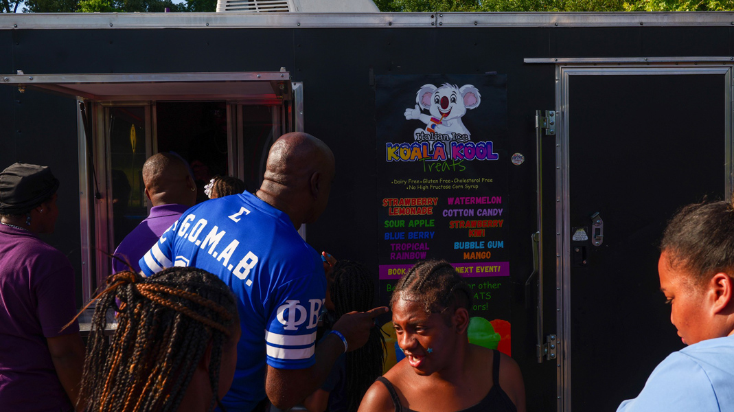 An attendee reviews th food truck menu while waiting in line.