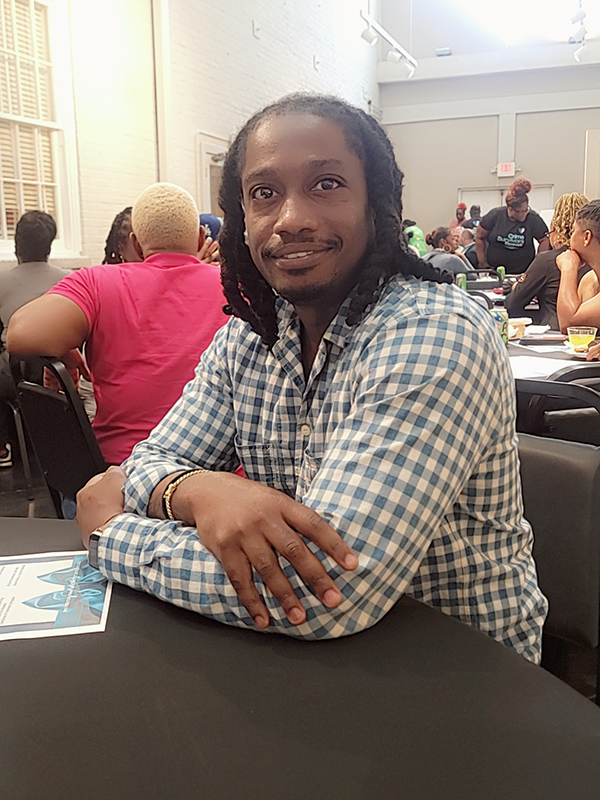 A grand opening attendee is seated at a table enjoying the event.