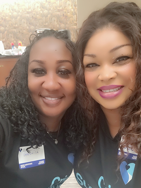 Two participants seated indoors wearing Crime Survivors Speak Mississippi shirts and name badges.