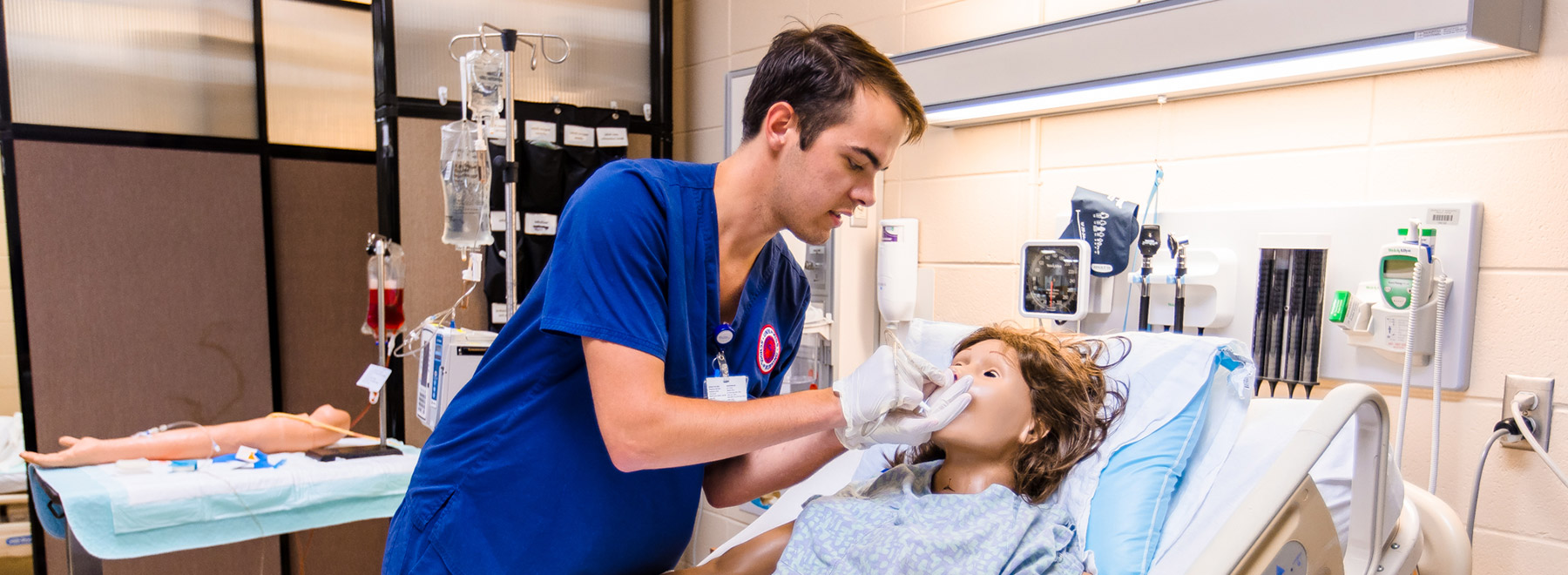 Pearce Lynn inserts a nasogastric tube to decompress a manikin's abdomen during a skills relay.