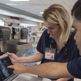 Nurse practitioner student confers with a doctor on a patient's X-ray.