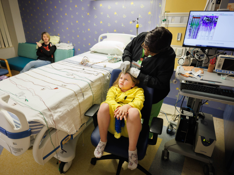 Yolandia Anderson, a polysomnographic technician, preps patient Naevia Dixon, 7, for a sleep study in the Pediatric Sleep Clinic in Batson Tower.